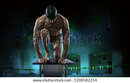 Swimming pool. Muscular swimmer ready to jump. Royalty-Free Stock Photo #1208582254