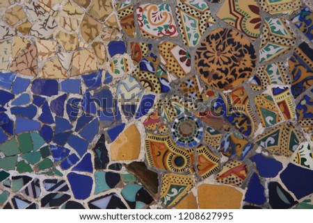 a close up colorful ceramic pattern mosaic tile by Antoni Gaudi in magnificent park Guell on the hills of Barcelona, Catalonia, Spain
