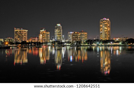 Cityscape at night reflecting in the water.