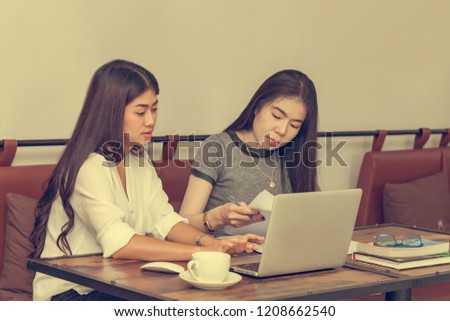 Two young women sit at the desk. Young businesswoman sitting at work desk
