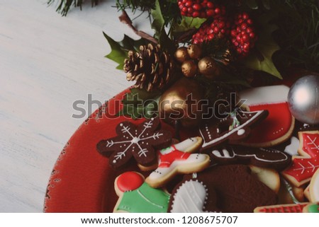 Close up view of colorful Christmas cookies with festive decoration on wooden table. xmas holiday concept.
