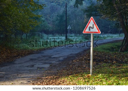 Narrow road through autumn woods