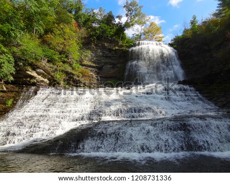 Beautiful waterfall cascading over multiple layers of rock into Seneca Lake in Finger Lakes in New York