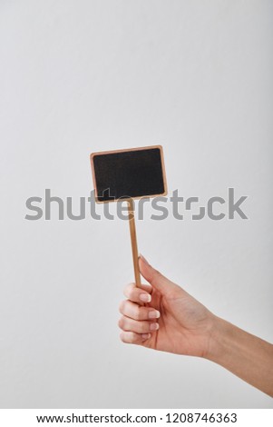 Woman holding a blank blackboard display label on white background
