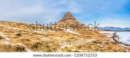 Panoramic view of Kirkjufell mountain, mean Church mountain, the most popular landmark of Iceland, cold freeze in winter season under blue sky