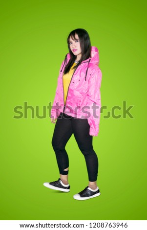 Full length of female hip hop dancer looks confident while standing in the studio with green screen