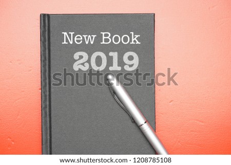 Business concept - top view of black book and pen with wording of "New Year" and "2019"