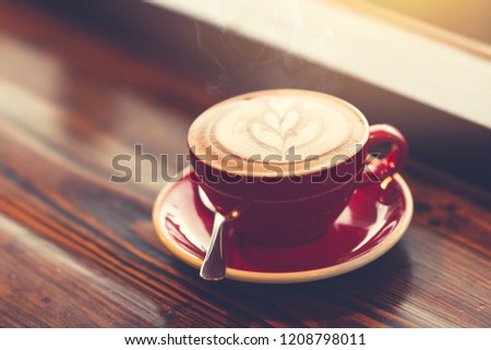 good morning coffee at windows on wooden table with latte art vintage color tone.