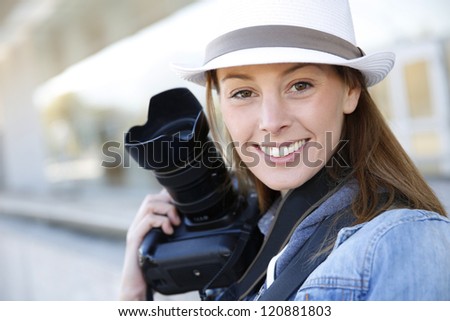 Beautiful woman photographer holding photo camera