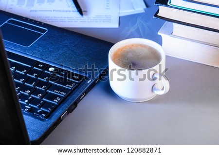 working at night, laptop with documents and cup of coffee on table