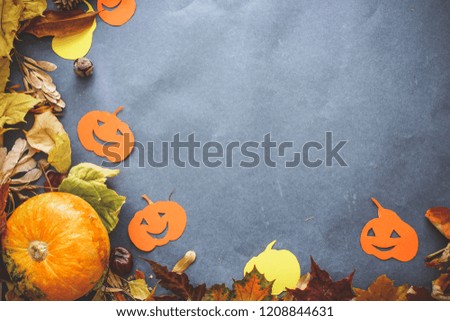 Halloween festive still life.
compositions from real small pumpkins, pumpkins cut out of cardboard, autumn leaves and knobs