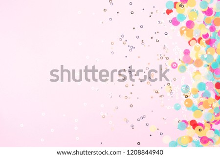 Festive pink background with colorful confetti and sparkles.