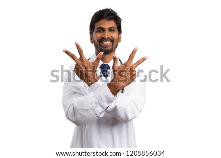Positive inidan doctor holding up three fingers at both hands as counting concept isolated on white studio background