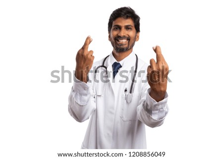 Male doctor or medic holding fingers crossed as good luck concept isolated on white