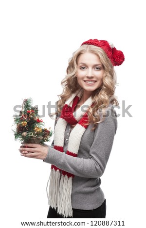 young blond smiling casual woman in red scarf and hat holding christmas tree