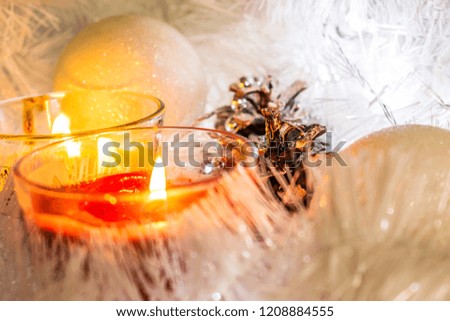 Christmas composition of white jewelry. Tinsel, cones, lanterns and candles. White Christmas snow. Shiny holiday decorations in warm soft light with wax candles. Picture of magic night
