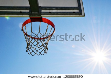 Basketball outdoor court sport game blue sky background design. Basketball basket and board on the blue sky background.  Basketball hoop and against blue sky and sun
