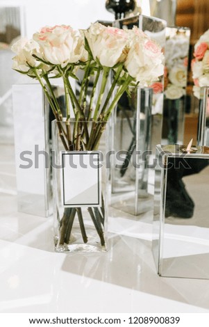 White blank sticker on glass vase with roses flowers empty tag. Selective focus. Place for text