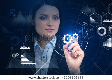 Young businesswoman using infographics interface with cogwheels and hud. Toned image double exposure