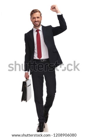 excited businessman stepping on white background and celebrating his new job with arm in the air, full length picture