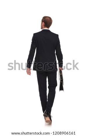 rear view of blonde businessman walking and looking to side on white background, full body picture