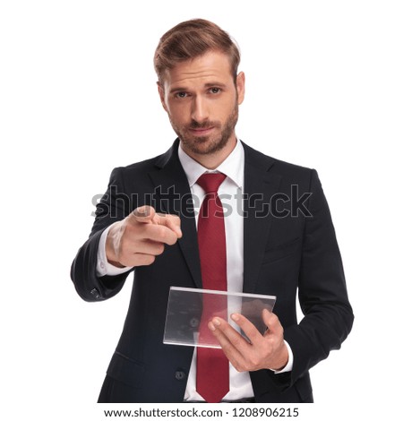 handsome businessman holding futuristic tablet points finger while standing on white background, portrait picture