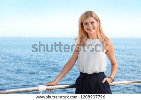 Portrait of beautiful blonde woman near sea, space for text