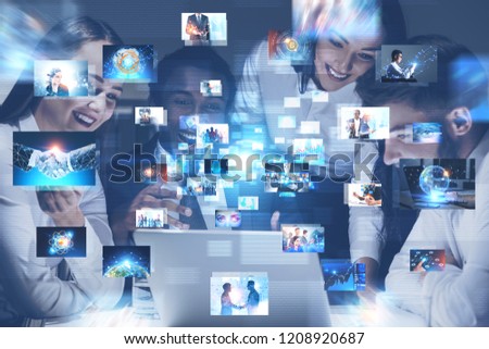 Diverse business team members working in office with many business themed pictures in the foreground. Concept of hi tech and big data. Toned image double exposure