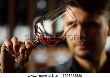 Bokal of red wine on background, male sommelier appreciating drink Royalty-Free Stock Photo #1208948620