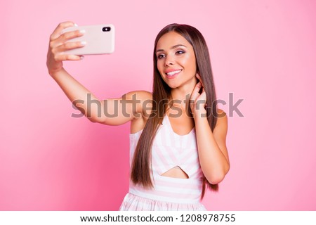 Cheerful charming cute sweet pretty attractive lady she hold gadget in her hand make selfie and beaming toothy smile stand isolated on bright pastel pink background in white elegant wear