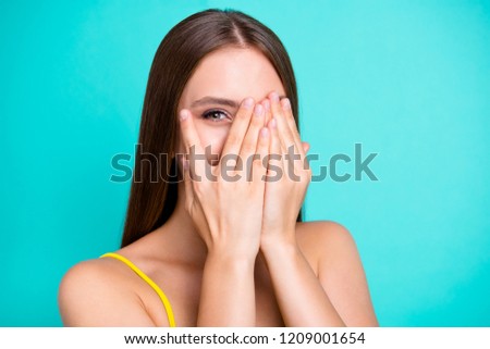 Close-up portrait of nice funny positive cheerful attractive straight-haired girl, covering face with palms, one eye peeping, isolated on green turquoise background