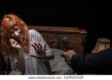 Scary woman possessed by devil in the bed. Exorcism of priest. 