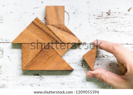 Tangram puzzle wait to fulfill home shape on old white wood background (conept for build dream home, happy life, house or mortgage investment)