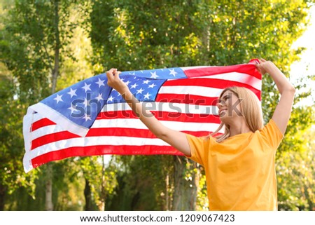 Woman with American flag in park on sunny day