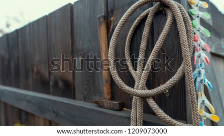 Rope and hammer on a wooden fence.