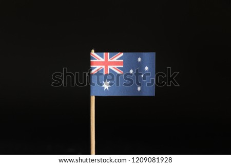 A national Flag of Australia on wooden stick on black background. State belongs on australia continent. Rugby is a national sport