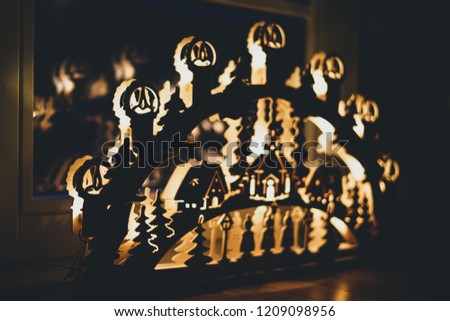handmade candle arch from Germany based mountain range Erzgebirge standing on parquet and illuminates the floor on Christmas time