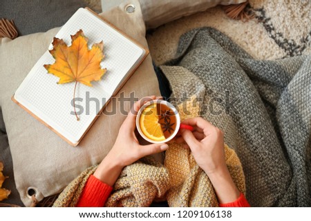 Young woman with cup of hot tea resting at home
