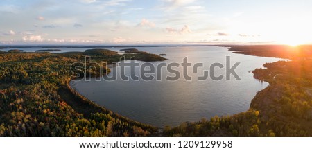 Aerial panoramic landscape view of a beautiful bay on the Great Lakes, Lake Huron, during a vibrant sunset. Located Northwest from Toronto, Ontario, Canada. Royalty-Free Stock Photo #1209129958
