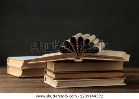 A stack of books on a brown wooden table and on a black background. Old books. Education. school. study
