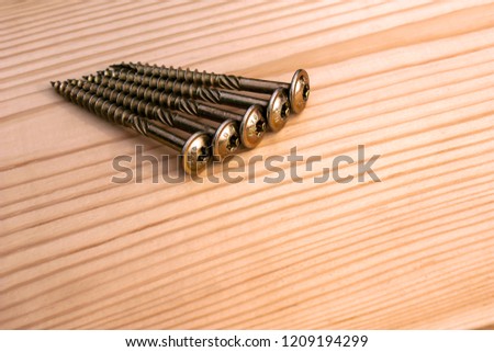 Five screws on wood background