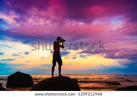 Silhouette of a young man are shooting photos on the mountain,Outdoor travel adventure concept.