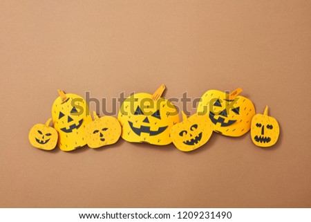 Different handcraft scary pumpkins on a brown background with space for text. Creative composition for Halloween. Flat lay