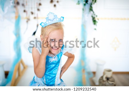 Prepare for the new year party, the snow queen or the Snow Maiden princess. Beautiful girl with a cardboard caron. Blonde holding a decoration on a wooden stick. Original accessories for photo shoots