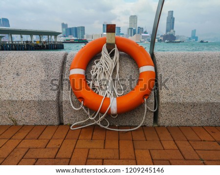 Orange rubber life jackets hanging side wall at Victoria Harbor
