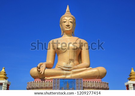 Beautiful of golden Big Buddha against blue sky background in Sing Buri, Thailand.