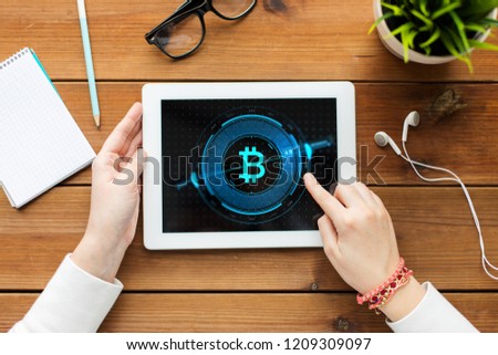 business, education, technology, people and advertisement concept - close up of hands with bitcoin symbol on tablet pc computer screen