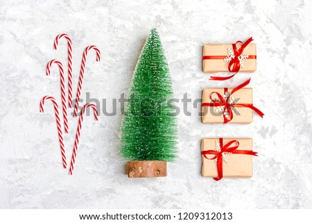 Happy new year composition. Christmas decoration tree, gifts, glitter, Christmas balls, candy, snowflakes on gray concrete  background. Flat lay, top view.Copy space