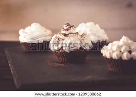 Chocolate cupcake with cream on top on  slate plate