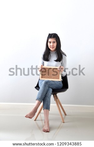 Beautiful young Asian woman Bulletin Board guts pose gesture sitting in a chair on white wall background, Picture includes copy space, For the holiday background design. discount Business
